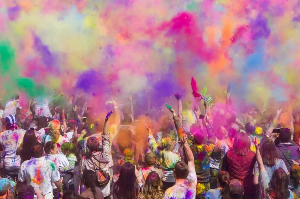 A family sharing sweets and smiles, celebrating the warmth and joy of Holi 2024 with traditional delicacies