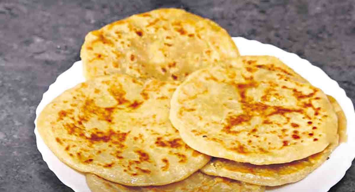 A plate of freshly made Bobbatlu alongside a festive spread 