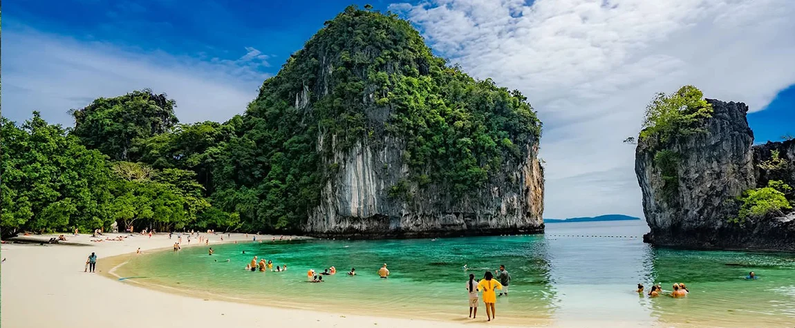 Rock climber scaling limestone cliffs in Railay Beach, Krabi 