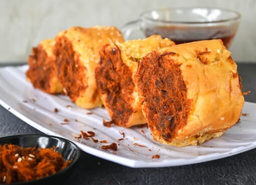 Potongan abon gulung roti yang renyah, disajikan hangat dengan saus sambal